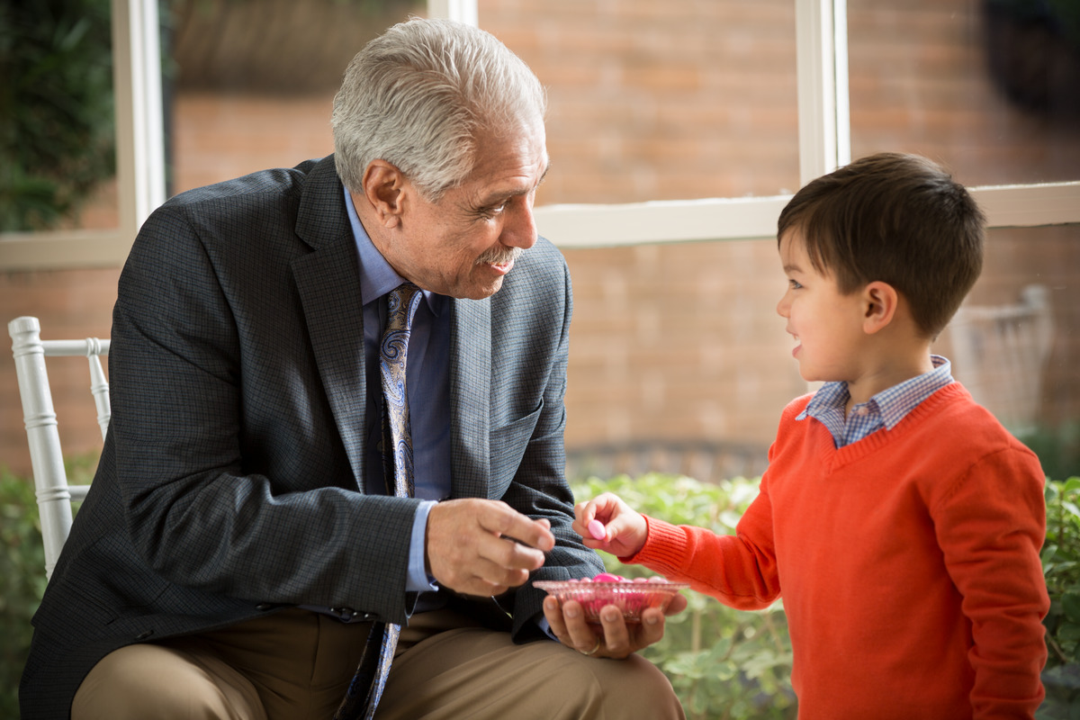 A grandfather talking to his grandson at a reception.