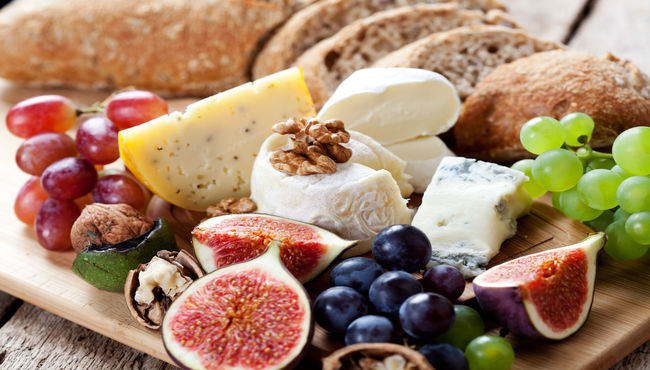 A spread of kosher appetizers including cheese and nuts.