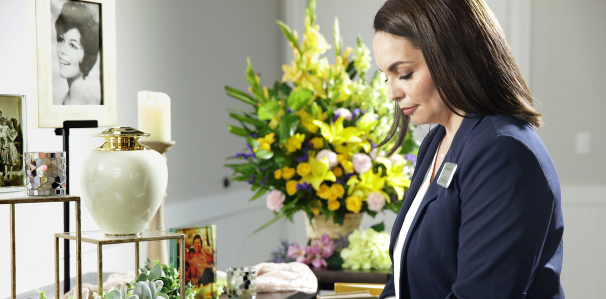 A female Dignity Memorial associate decorates a Memory Table for a celebration of life