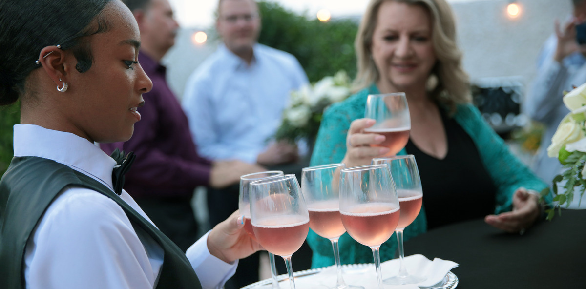 A waiter providing refreshments at an outdoor celebration