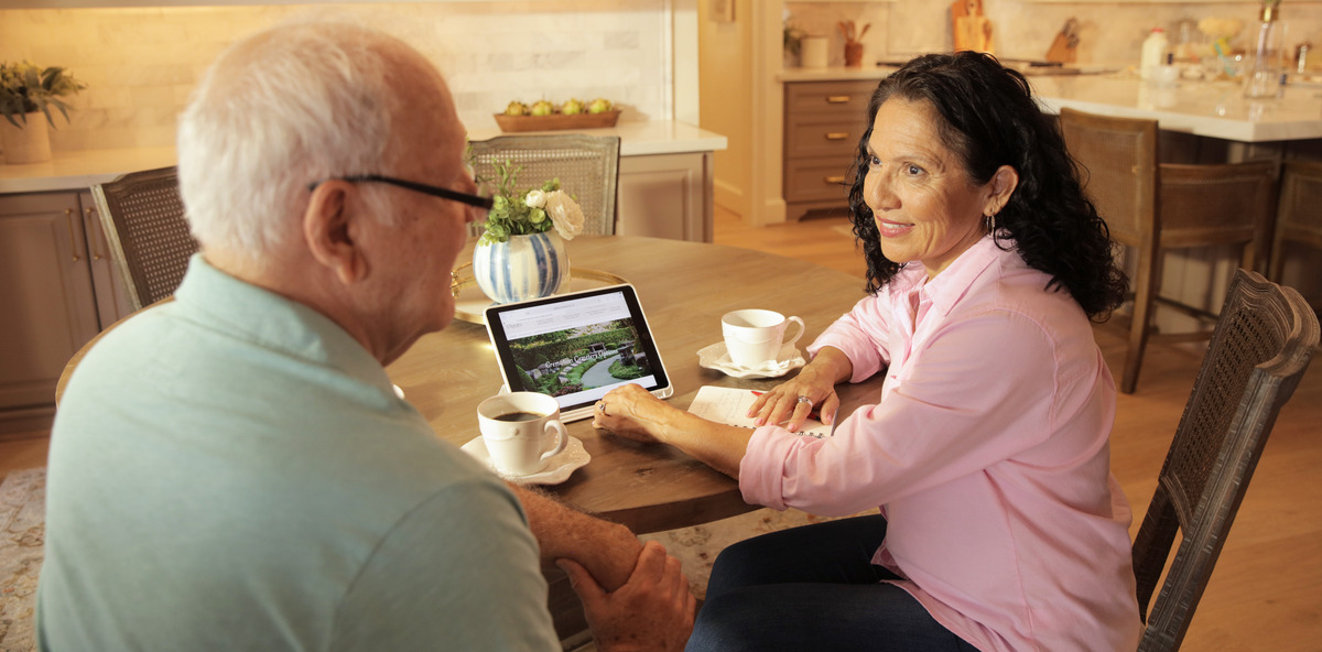 Elderly couple pre-planning on a tablet for a personalized funeral service 