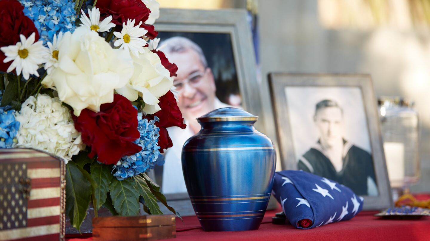 Cremation memorial for a U.S. Veteran with patriotic colors and photographs.